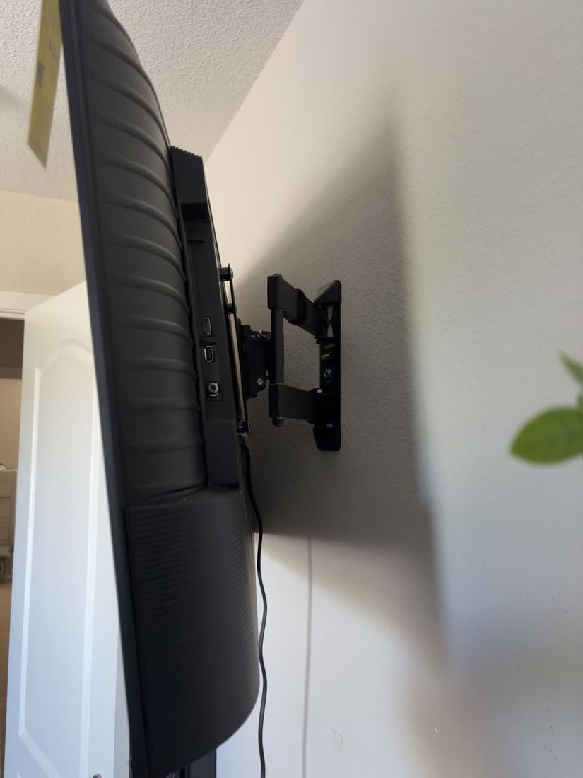 TV mounted on a wall with an articulating arm
